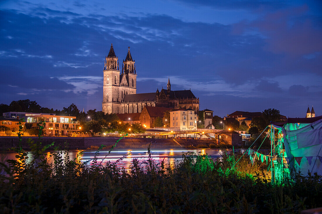 Magdeburg Cathedral at dusk, in front of it the illuminated Elbe promenade, party tent on the riverside, Magdeburg, Saxony-Anhalt, Germany