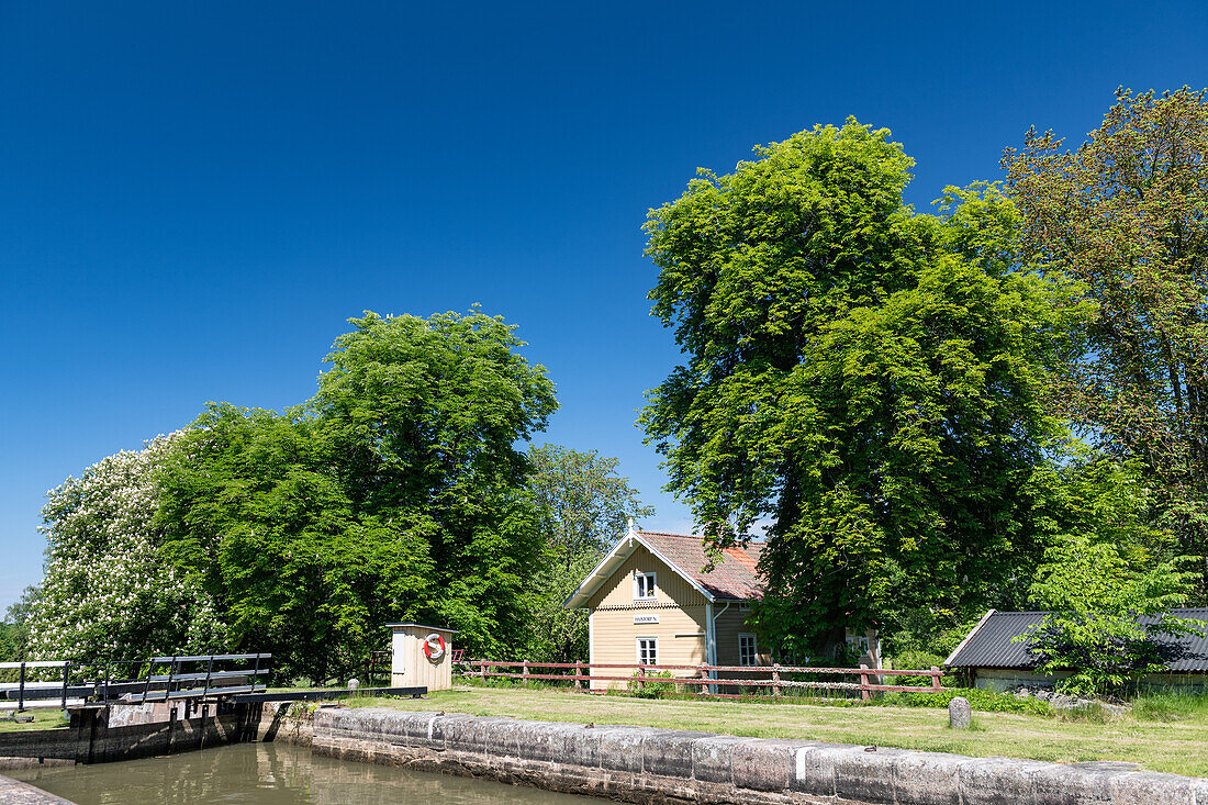 Lock on the Göta Canal with bridge and house in Hajstorp, Västra Götaland, Sweden