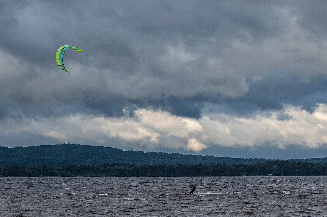 Kitesurfer bei Sturm und dunklen Wolken am Siljansee, Rättvik, Dalarna, Schweden