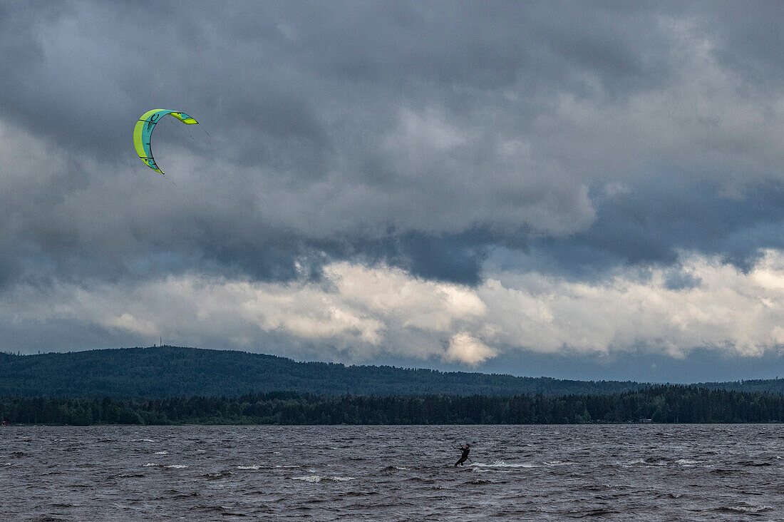 Kitesurfer in storm and dark clouds at Lake Siljan, Rättvik, Dalarna, Sweden