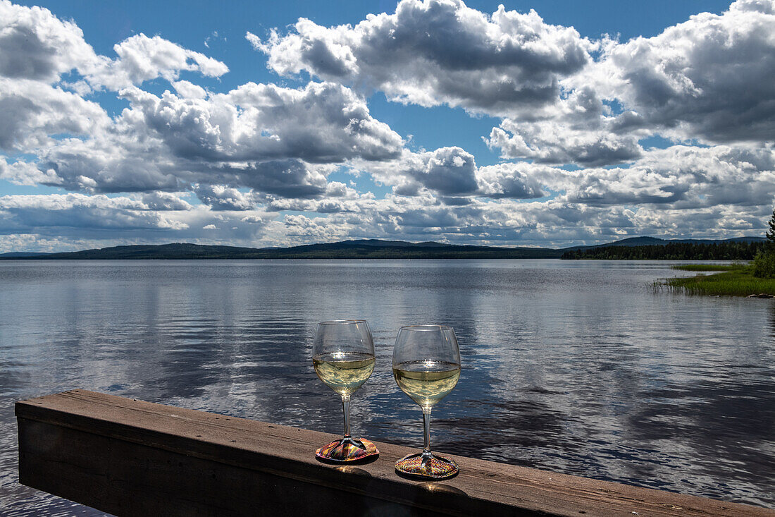 Zwei Weingläser auf dem Geländer am Siljansee bei Sollerön, Dalarna, Schweden