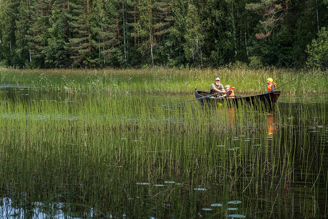 Vater angelt mit seinen Söhnen auf einem See, Zwischen Juva und Sulkava führt die bekannte Kanutour Eichhörnchen Tour (Oravareitti) entlang, Finnische Seenplatte, Finnland