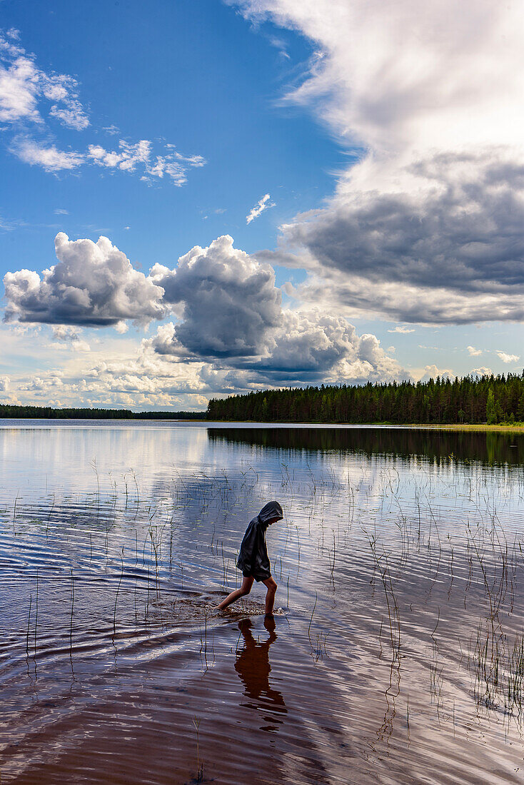 Junge am Ufer im Patvinsuo-Nationalpark, Finnland