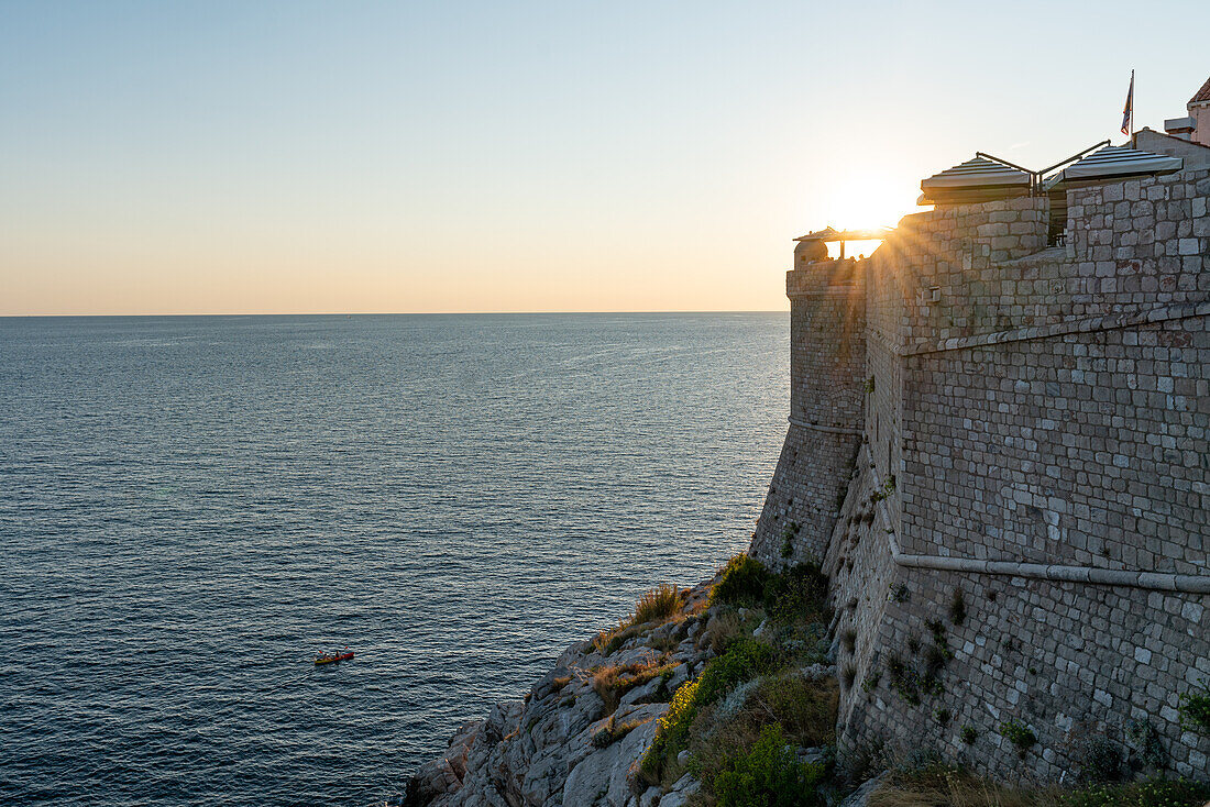 Sonnenuntergang mit Blick aufs Meer und die Stadtmauern der Altstadt von Dubrovnik, Dalmatien, Kroatien.