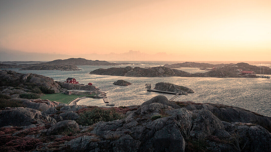 Rote Hütte an der Küste bei Skärhamn auf der Schäreninsel Tjörn an der Westküste von Schweden im Sonnenuntergang\n