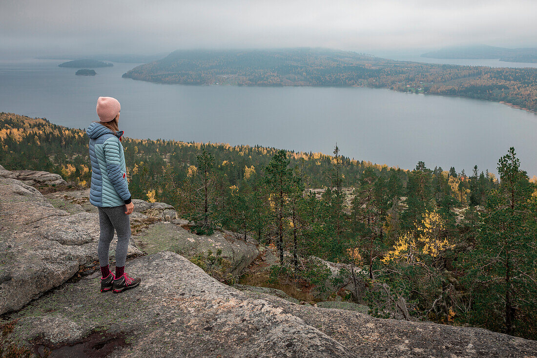 Frau auf dem Getsvedjeberget mit Blick über die Landschaft von Höga Kusten im Osten von Schweden\n