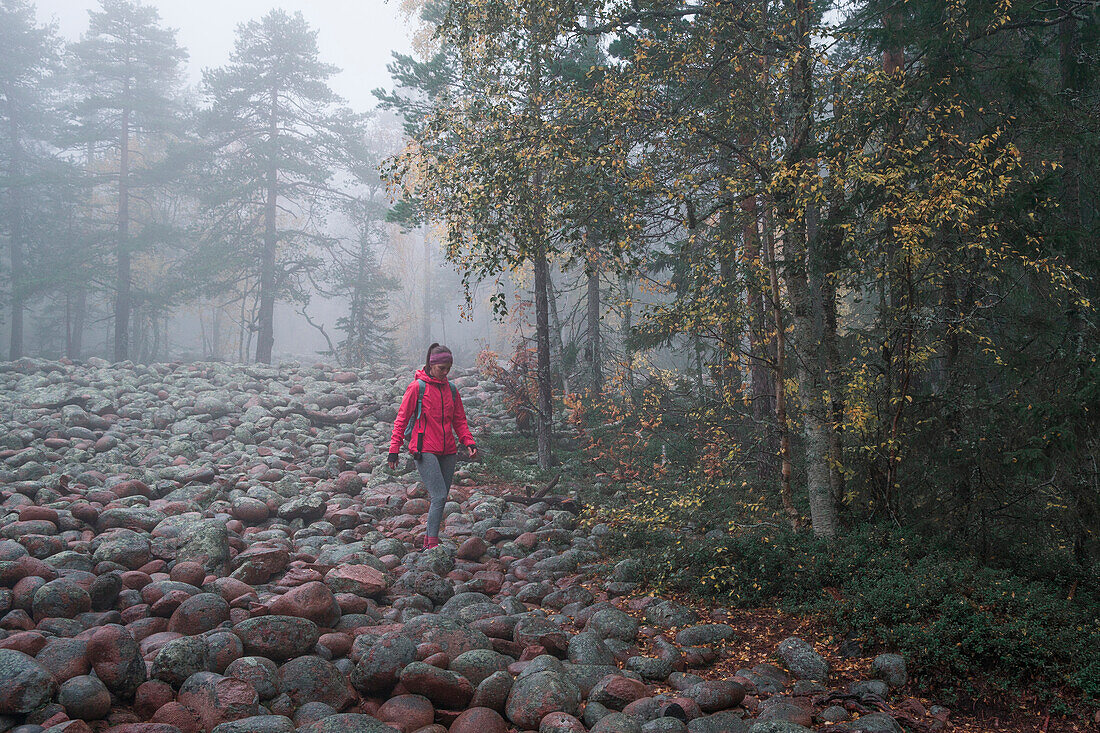 Woman hikes through stone field in Skuleskogen National Park in eastern Sweden