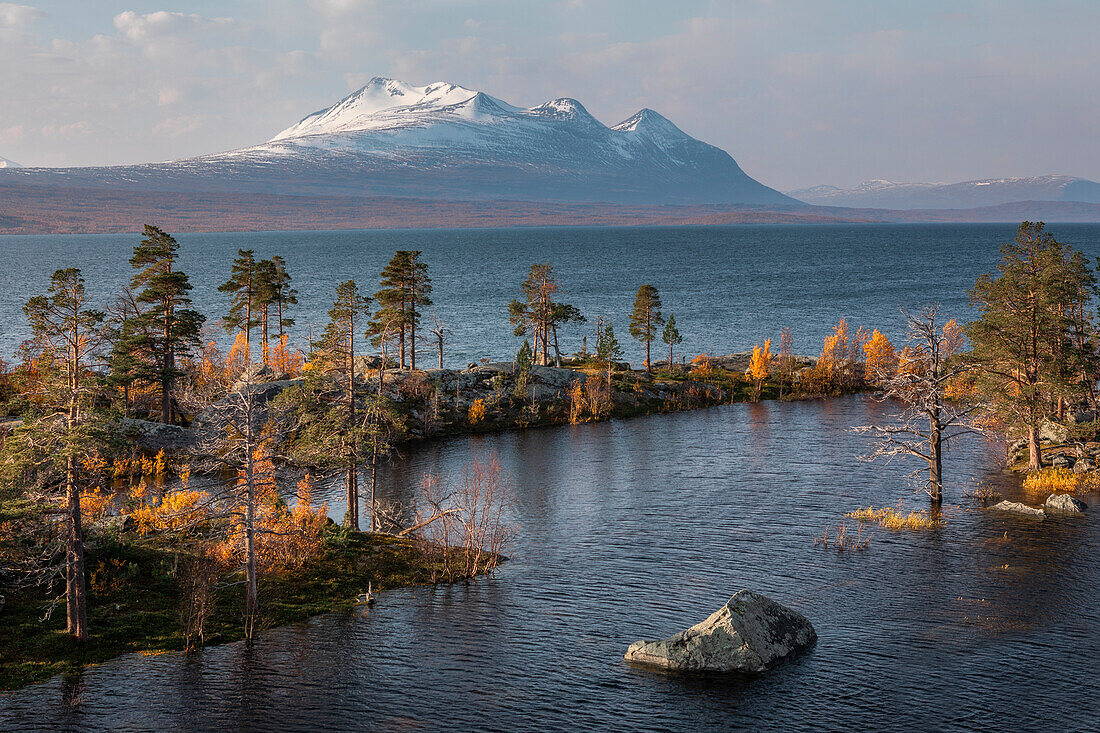 Landschaft mit verschneiten Bergen des Sarek Nationalpark und See im Stora Sjöfallet Nationalpark im Herbst in Lappland in Schweden