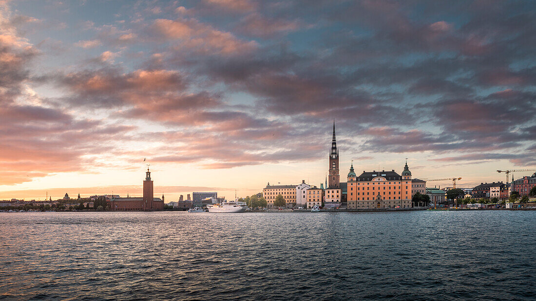 Skyline von Stockholm bei Sonnenuntergang mit Kirche Riddarholmskyrkan auf Altstadtinsel Gamla Stan und Stadshus in Schweden\n