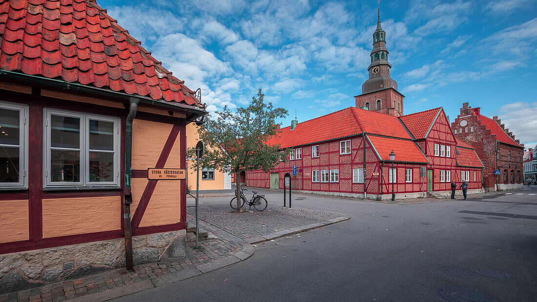 Hausfassaden, Straße und Kirche in Ystad in Schweden bei Sonne\n