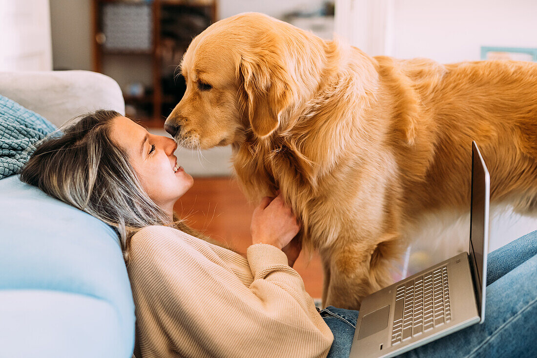 Italy, Young woman with dog at home