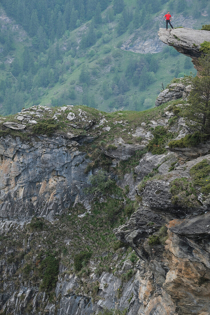 Mann steht am Rande der schroffen Bergklippe, Piemont, Italien
