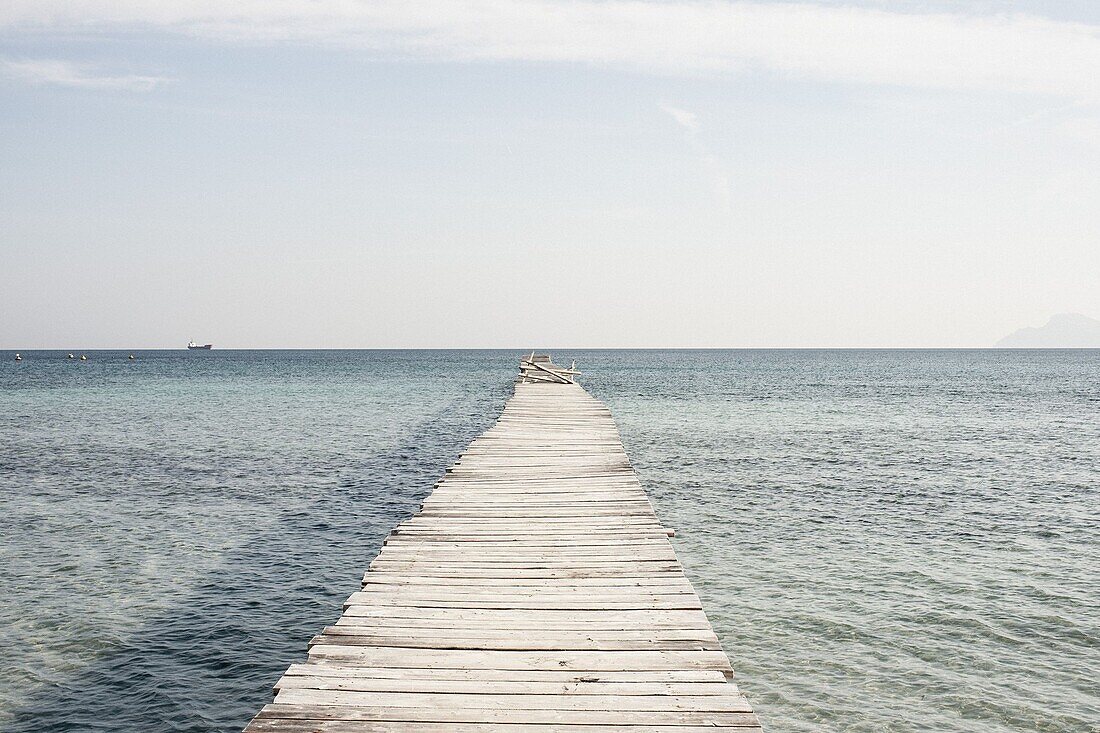 Hölzerner Pier, der sich ins sonnige Meer erstreckt, Mallorca, Spanien