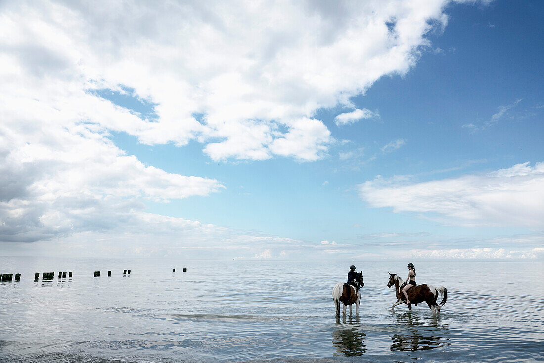 Mädchen auf Pferden in der Ostsee, Deutschland