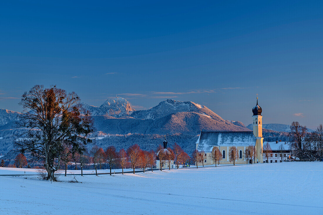 Snow-covered meadows with Wilparting Church and mountains of the Wendelstein area in the background, Irschenberg, Upper Bavaria, Bavaria, Germany