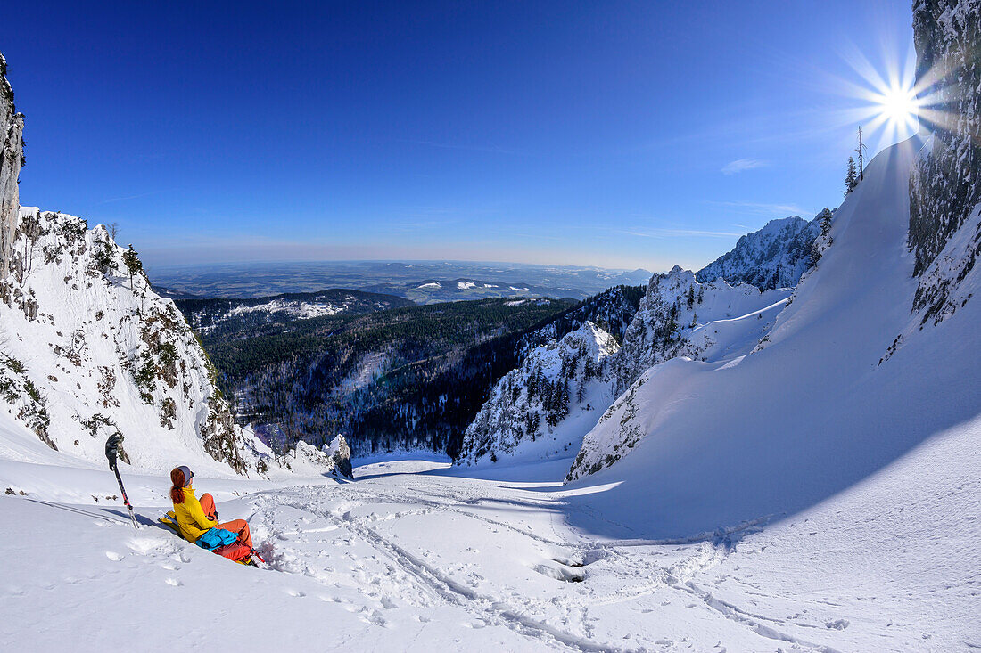 Frau auf Skitour macht in großem Schneekar Pause, Zwiesel, Chiemgauer Alpen, Oberbayern, Bayern, Deutschland