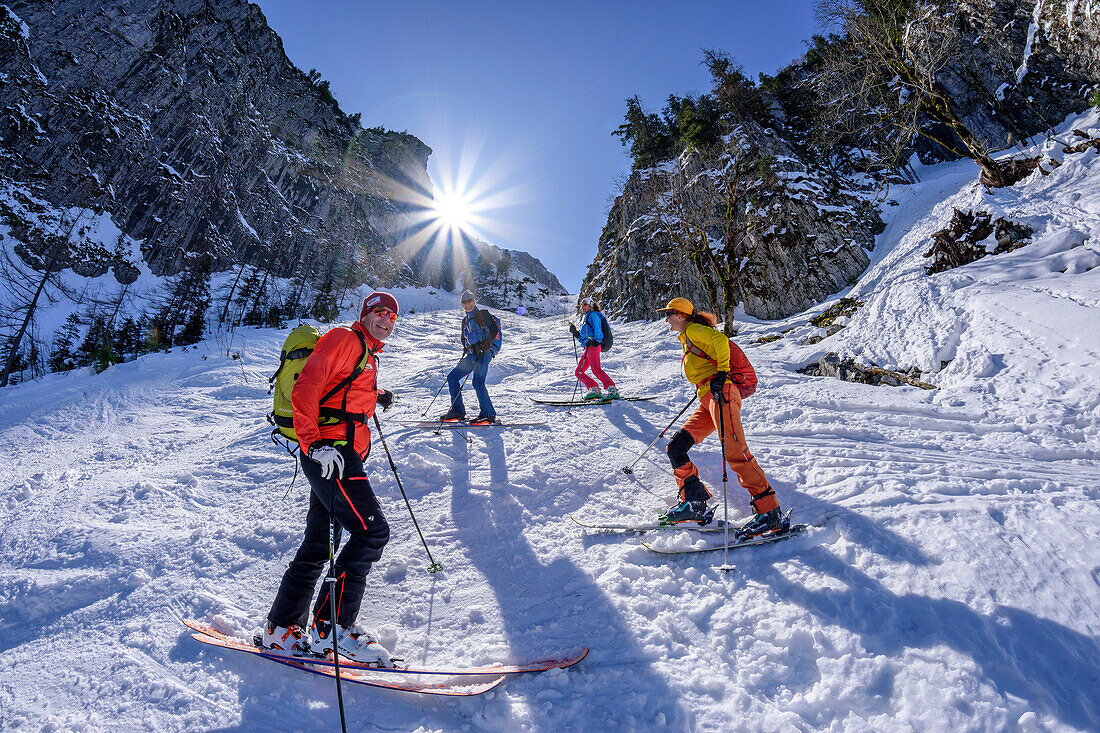 Vier Personen auf Skitour stehen in einer Schneerinne, Rauschberg, Chiemgauer Alpen, Oberbayern, Bayern, Deutschland