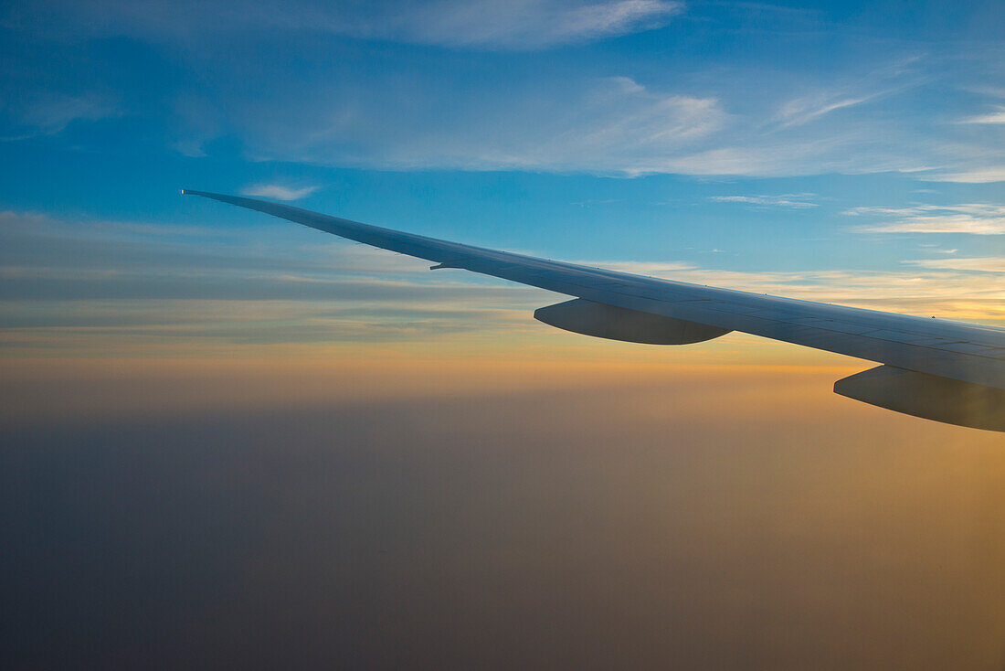Flugzeugflügel im Sonnenuntergang über den Vereinigten Arabischen Emiraten