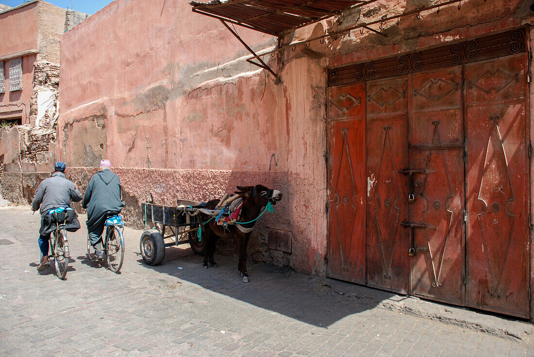 zwei marokkanische Männer auf einem Fahrrad in den Straßen der Medina von Marrakesch, Marokko, Nordafrika, Afrika