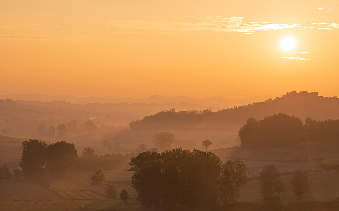 Traumhafter Sonnenaufgang übder den Hügels des Piemont, Italien, Europa