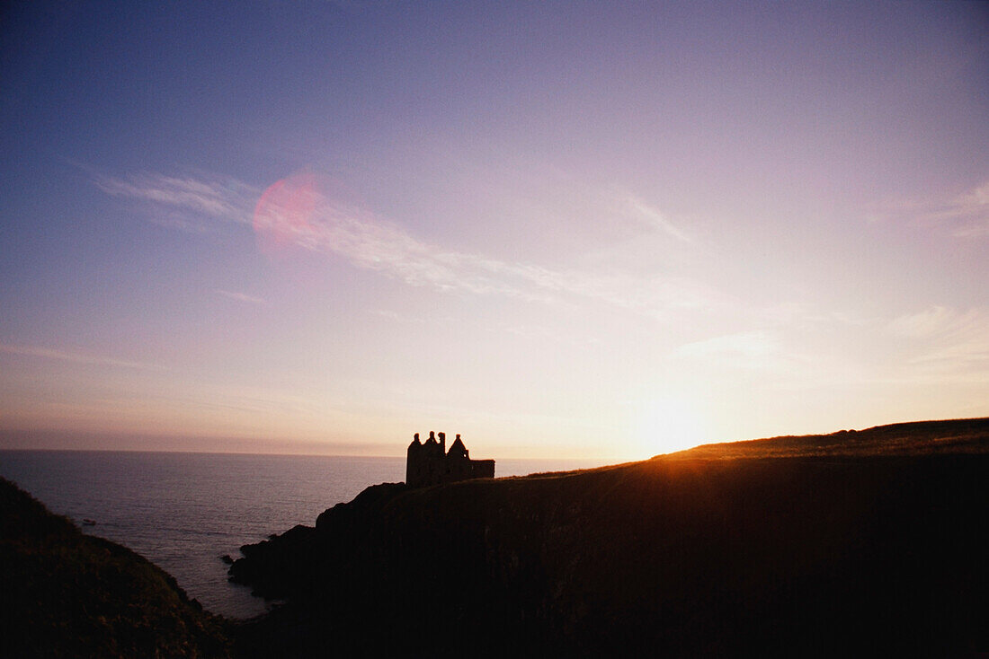 Silhouette of a stone castle on the coast, Scotland