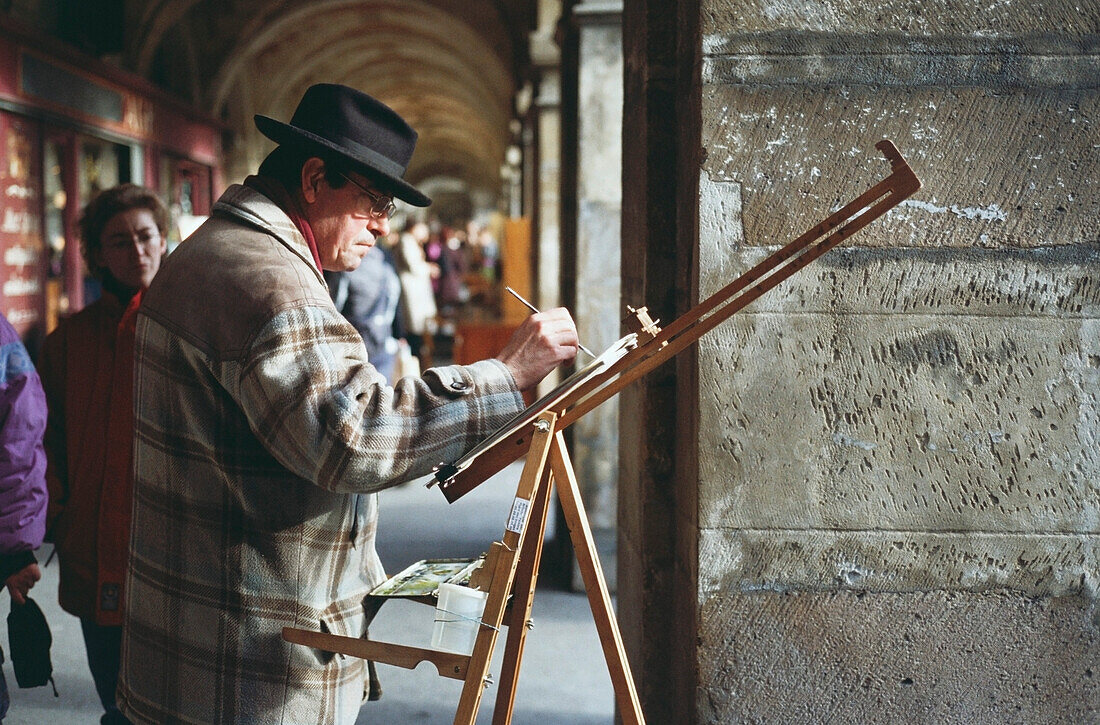 Artist painting at a market, Paris, Ile-de-France, France