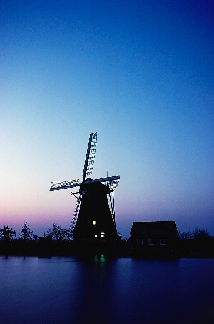 Silhouette einer traditionellen Windmühle bei Sonnenuntergang, Niederlande