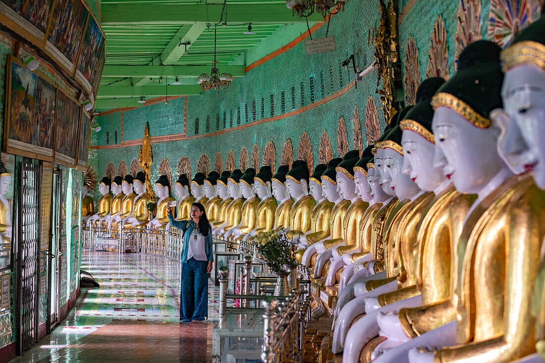 Eine Frau macht ein Selfie in der U Min Thonze-Pagode auf dem Sagaing Hill in Myanmar