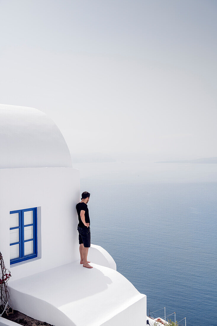 Man talking on the phone on house roof, Oia, Santorini, Santorin, Cyclades, Aegean Sea, Mediterranean Sea, Greece, Europe