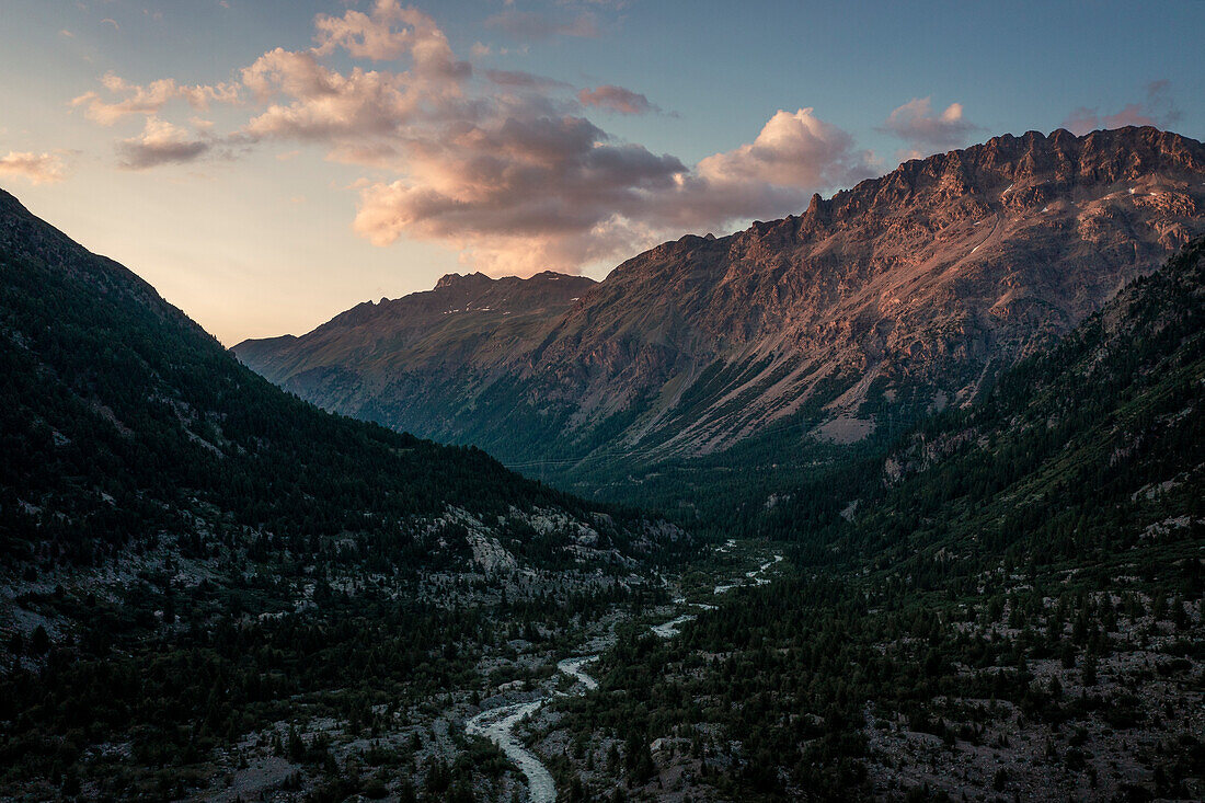 Glacier valley with river at Morteratsch Glacier in Engadin in Swiss Alps in summer from above in sunset