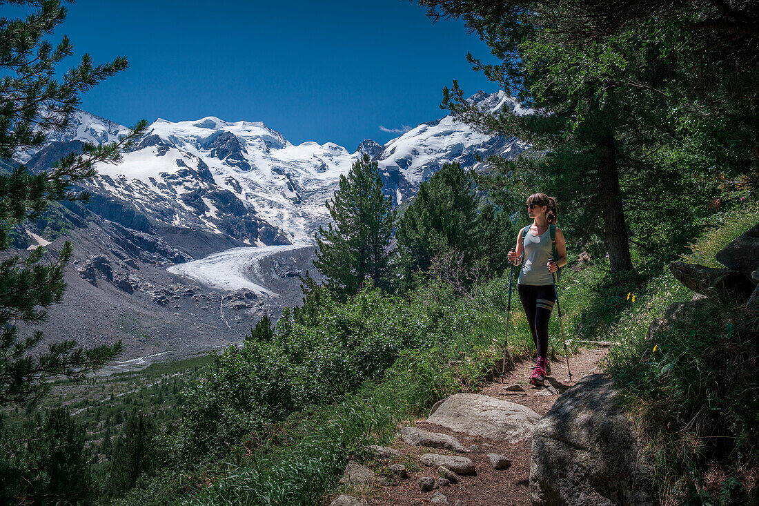 Woman hikes on path on Morteratsch Glacier in the Engadin in the Swiss Alps in summer