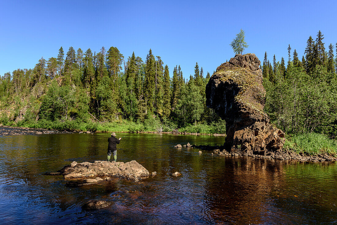 At the Rupkivi characteristic rock in the Savinajoki river, anglers on the Bear Circle hiking trail, Finland
