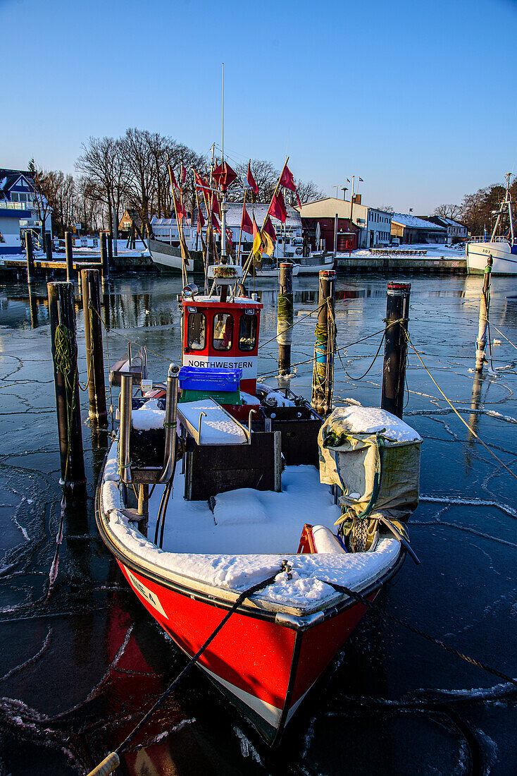 Small fishing boats in the icy harbor of Niendorf, Bay of Lübeck, Schleswig Holstein, Germany