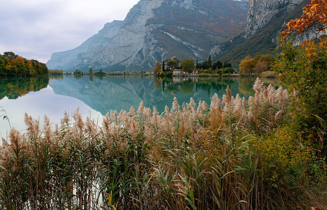 Lake Toblino with the castle in autumnal guise. It is a small Alpine lake in the province of Trento (Trentino-Alto Adige) and has been declared a Biotope for its naturalistic qualities. Location used for film production. Italy