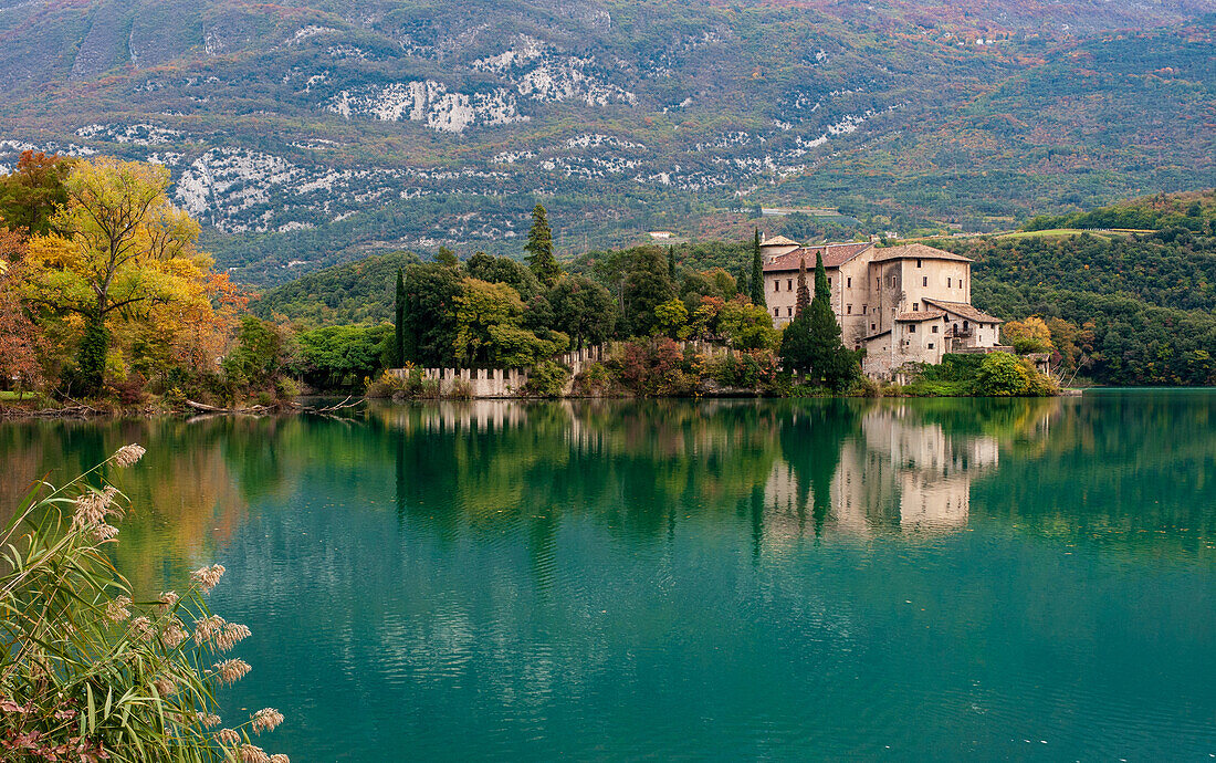 Toblinosee mit Schloss im Herbst, kleiner Alpensee in der Provinz Trient (Trentino-Südtirol), Biotop, Italien