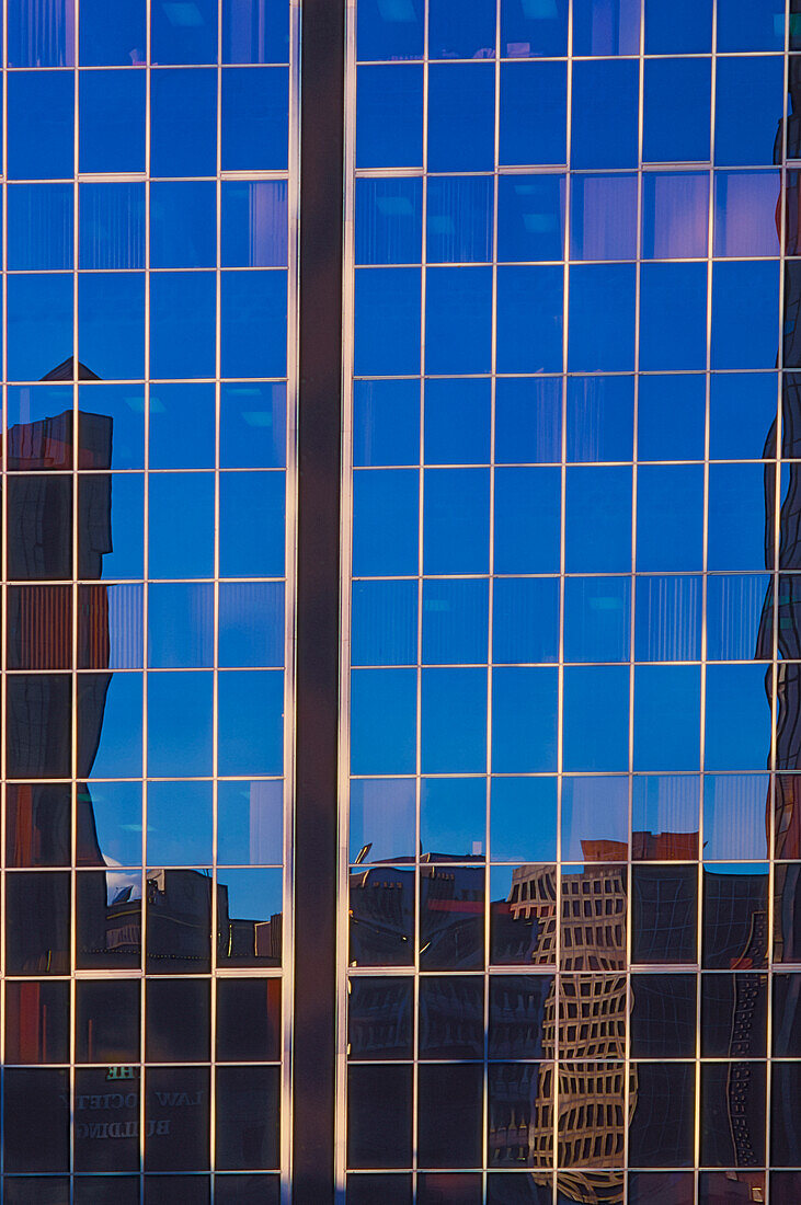 City reflecting in large glass skyrise building