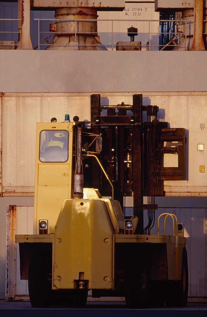 Close up of forklift working with shipping containers at the port