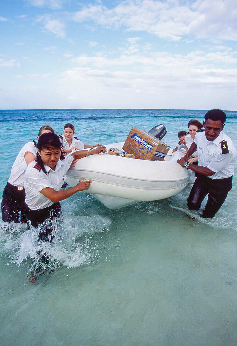 Medizinisches Team und Freiwillige landen mit einem Schlauchboot auf der tropischen Insel, um Barmherzigkeit zu erreichen