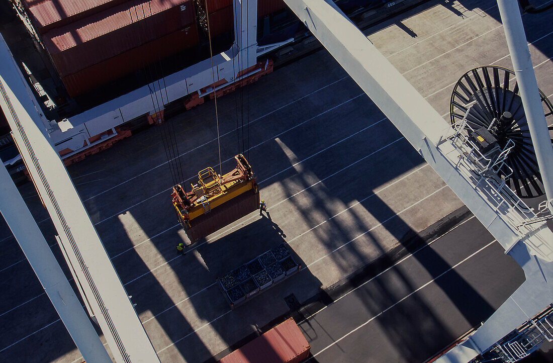 Looking down from crane at shipping container being secured for loading