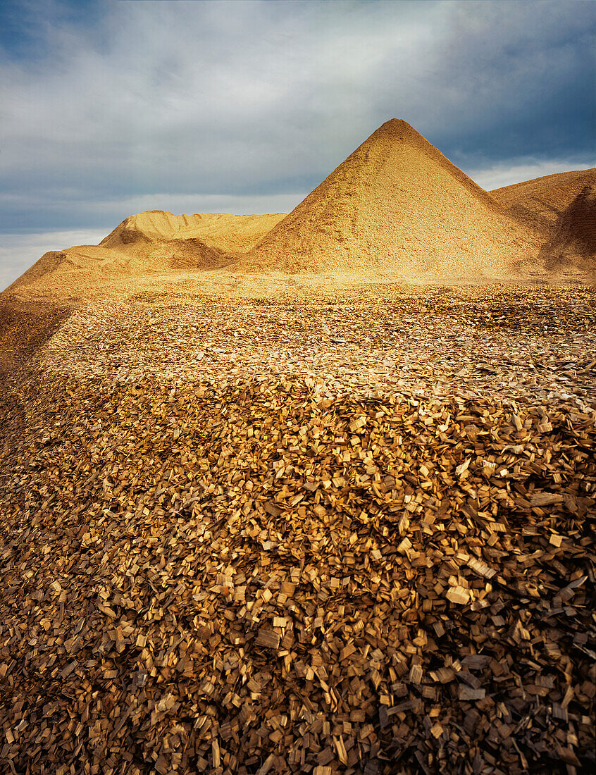 Pile of woodchips against cloudy sky ready for export