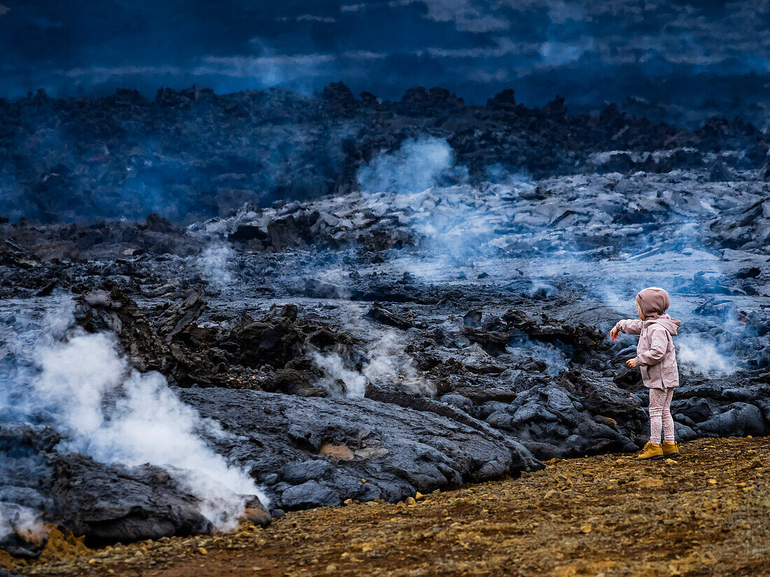 Kleines Mädchen, das Lava testet, einheimische Isländer, die Lavaströme vom Vulkan Fagradalsfjall, Island, besuchen