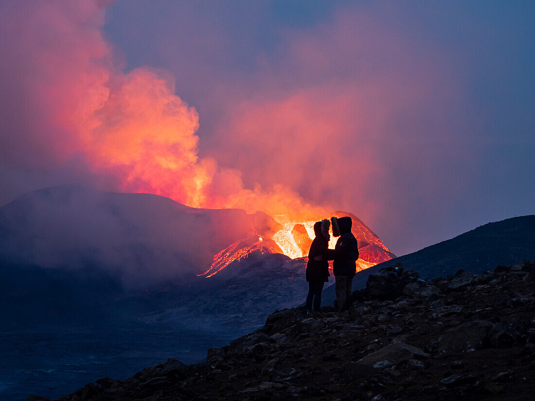Couple enjoys eruption of Fagradalsfjall Volcano from Observation Hill, Iceland