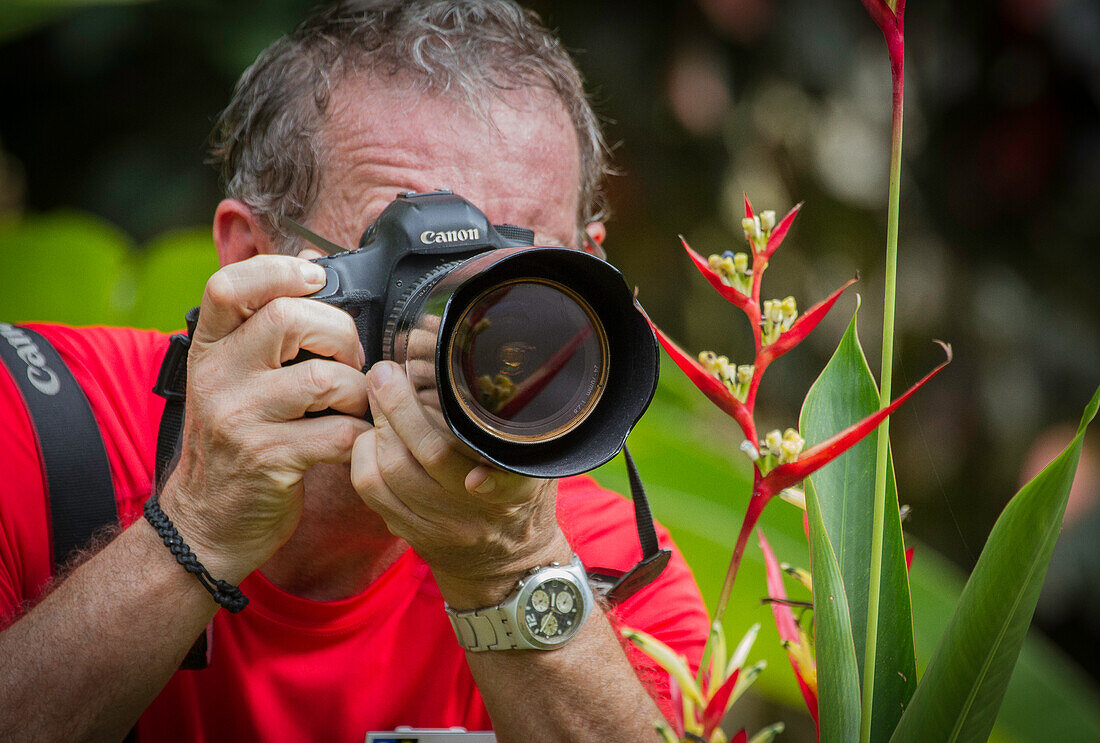 Ein Fotograf fotografiert bunte tropische Blumen