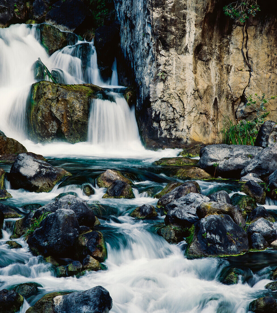 Wasser fließt über Felsen und flussabwärts bei Tarawera Falls