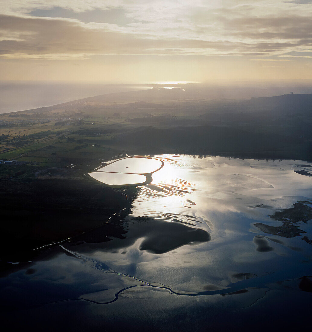 Aerial at dawn of estuary and surrounding farmland along coastline of Bay of Plenty, New Zealand