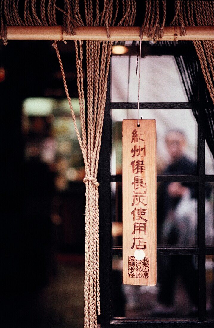 Wooden charm hanging from window, Tokyo, Japan