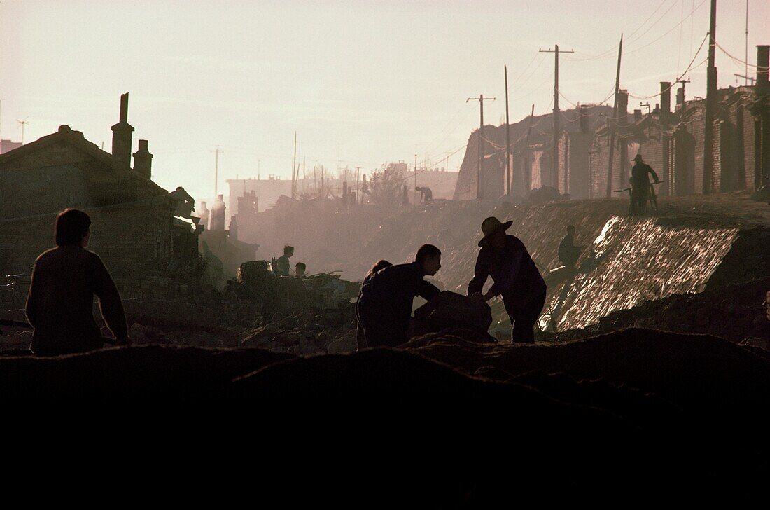 Männer arbeiten in einem Graben bei Sonnenaufgang, China