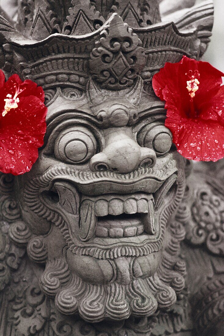 Indonesian sculpture of a lion with hibiscus flowers on both sides of the head, Bali, Indonesia