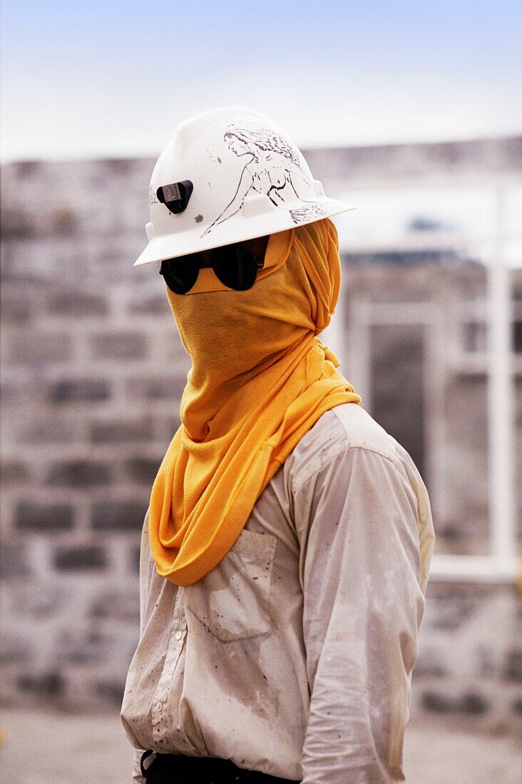 Mann mit Schutzhelm, verziert mit Zeichnung einer Frau mit Sonnenbrille und gelbem Tuch über seinem Gesicht zum Schutz während des Bergbaus, Irian Jaya, Neuguinea, Indonesien