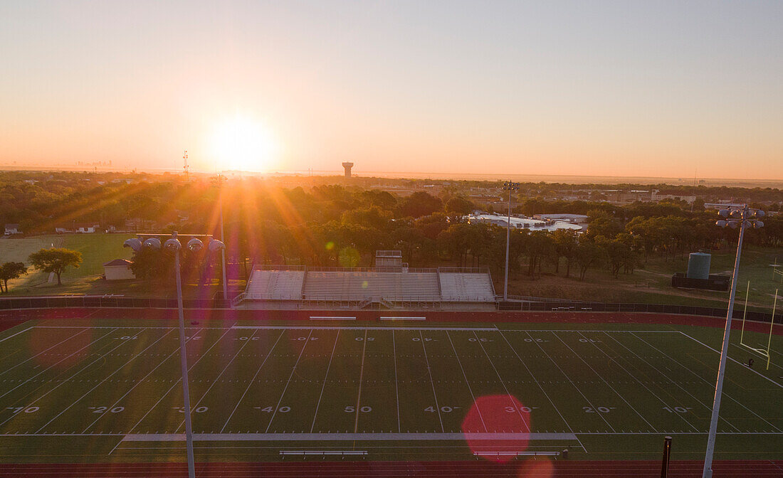 Luftaufnahme einer Highschool-Laufbahn und eines Fußballplatzes in Texas bei Sonnenaufgang
